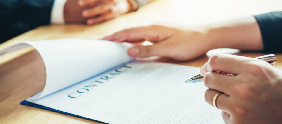 A woman getting ready to sign a contract - How to Draft an Employment Agreement