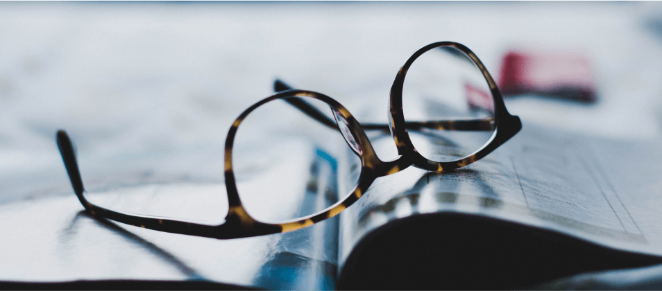 A picture of glasses on a magazine - Invoice Factoring Explained