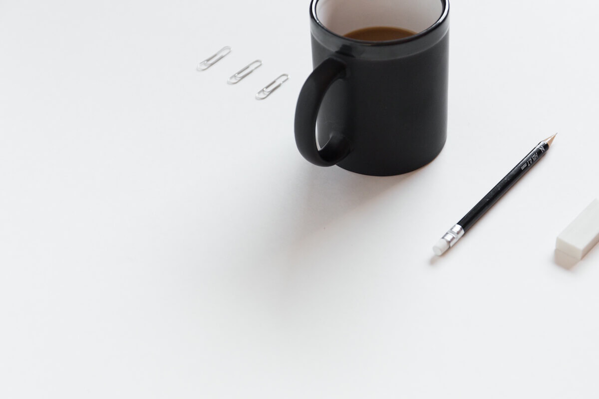 A cup of coffee and a pencil - Pricing Strategy Guide: Service Businesses